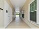 Bright hallway leading to pool access featuring an office door and views of the pool area at 2216 Evans Rd, Clearwater, FL 33763