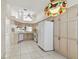 Bright kitchen featuring tiled floors, neutral countertops and cabinetry, and high ceilings with fan at 2216 Evans Rd, Clearwater, FL 33763
