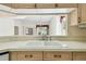 Close-up of the kitchen sink showcasing a double basin and a view into another living area at 2216 Evans Rd, Clearwater, FL 33763