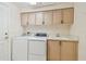 Laundry room featuring front load washer and dryer, utility sink, and upper cabinets for storage at 2216 Evans Rd, Clearwater, FL 33763