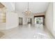 Open living room with tile flooring, chandelier, and view of lanai through sliding glass doors at 2216 Evans Rd, Clearwater, FL 33763