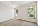Sunny main bedroom with two large windows, carpeted floor, and neutral wall color at 2216 Evans Rd, Clearwater, FL 33763
