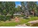 Lush backyard with brick walkway, mature trees, and lake views, creating a tranquil outdoor space at 2617 Heatherwood Dr, Tampa, FL 33618