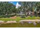 Backyard with manicured lawn and mature trees leading to a serene lake, offering a peaceful retreat at 2617 Heatherwood Dr, Tampa, FL 33618
