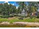 Scenic backyard featuring green lawn, mature trees, and picturesque lake, perfect for relaxation and entertainment at 2617 Heatherwood Dr, Tampa, FL 33618