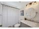 Charming bathroom features a marble vanity, bathtub with shower, and decorative lighting fixtures at 2617 Heatherwood Dr, Tampa, FL 33618