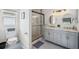 Well-lit bathroom featuring dual vanities, a walk-in shower, and unique patterned floors at 2617 Heatherwood Dr, Tampa, FL 33618