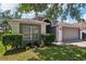 Attractive home exterior featuring lush landscaping, a two-car garage, and a well-manicured lawn at 2617 Heatherwood Dr, Tampa, FL 33618