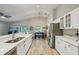 Bright kitchen features stainless steel appliances and white cabinets with a view of the dining area and backyard at 2617 Heatherwood Dr, Tampa, FL 33618
