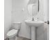 This half-bathroom features a pedestal sink, toilet, and modern fixtures at 33255 Kateland Dr, Wesley Chapel, FL 33545