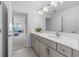 Bright bathroom featuring double vanity sinks with a white marble countertop and access to the bedrooms at 33255 Kateland Dr, Wesley Chapel, FL 33545