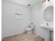 Bathroom with a pedestal sink, tiled floors, modern fixtures, and bright natural light at 33255 Kateland Dr, Wesley Chapel, FL 33545
