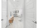 Bright bathroom featuring double doors, wood benches, and a vanity and shower in the background at 33255 Kateland Dr, Wesley Chapel, FL 33545