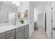 Bathroom with grey vanity, white countertop, large mirror, tiled floor, and modern fixtures at 33255 Kateland Dr, Wesley Chapel, FL 33545