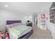 A bright bedroom featuring a window, neutral carpet, and vibrant purple accents, with ample space at 33255 Kateland Dr, Wesley Chapel, FL 33545