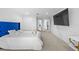 Bright bedroom featuring a blue tufted headboard and an en-suite bathroom view, for a luxurious home at 33255 Kateland Dr, Wesley Chapel, FL 33545