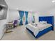 Carpeted bedroom with a bright blue bed and furniture set against white walls at 33255 Kateland Dr, Wesley Chapel, FL 33545