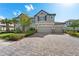 Beautiful two-story home boasting a three-car garage, paver driveway, lush landscaping, and a neutral color scheme at 33255 Kateland Dr, Wesley Chapel, FL 33545