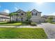 Charming home showcasing a well-manicured lawn, paver driveway, three-car garage and neutral color scheme at 33255 Kateland Dr, Wesley Chapel, FL 33545
