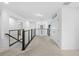 Bright upstairs hallway features neutral carpet, sleek railing, and leads to multiple rooms at 33255 Kateland Dr, Wesley Chapel, FL 33545