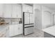 Kitchen featuring sleek white cabinets, stainless steel refrigerator, and modern design at 33255 Kateland Dr, Wesley Chapel, FL 33545