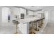 Elegant kitchen with an island, white cabinets, marble countertops, stainless steel appliances and stylish barstools at 33255 Kateland Dr, Wesley Chapel, FL 33545