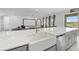 Modern kitchen featuring quartz countertops, farmhouse sink, and stainless steel appliances at 33255 Kateland Dr, Wesley Chapel, FL 33545