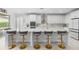 Modern kitchen with white cabinets, marble countertops, stylish barstools and stainless steel appliances at 33255 Kateland Dr, Wesley Chapel, FL 33545