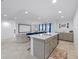 Spacious kitchen and living room with an island and a comfortable sofa and home theater at 33255 Kateland Dr, Wesley Chapel, FL 33545