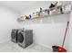 Bright laundry room with modern washer and dryer, shelving, and tile floors at 33255 Kateland Dr, Wesley Chapel, FL 33545