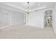 Large room featuring a tray ceiling with chandelier, with archway and tiled floor in distance at 33255 Kateland Dr, Wesley Chapel, FL 33545