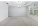 Spacious living room with neutral carpet and a tray ceiling with chandelier at 33255 Kateland Dr, Wesley Chapel, FL 33545