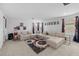 Neutral carpeted living room with decorative movie-themed decor and a large sectional sofa at 33255 Kateland Dr, Wesley Chapel, FL 33545