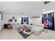 A sprawling sectional couch sits in a carpeted living room with cinema decor at 33255 Kateland Dr, Wesley Chapel, FL 33545