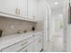 Butler's pantry with white cabinets, modern countertops, and neutral backsplash at 33255 Kateland Dr, Wesley Chapel, FL 33545