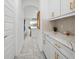 Butler's pantry with white cabinets, marble counters, and tile backsplash at 33255 Kateland Dr, Wesley Chapel, FL 33545
