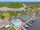 Aerial view showcasing community amenities, including a pool, tennis courts, and boat docks, with water access at 4012 Marine Pkwy, New Port Richey, FL 34652