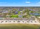 Aerial view showcasing a beachfront community with pristine sands, recreational areas, and waterfront homes at 4012 Marine Pkwy, New Port Richey, FL 34652