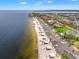 Scenic aerial view of a beachfront community with a long sandy beach, parking, and waterfront properties at 4012 Marine Pkwy, New Port Richey, FL 34652