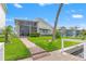 Backyard featuring a well-manicured lawn leading to a waterfront view from a private, screened sunroom at 4012 Marine Pkwy, New Port Richey, FL 34652