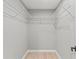 Walk-in closet with custom shelving and wood floor at 4012 Marine Pkwy, New Port Richey, FL 34652