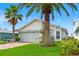 Charming home exterior with lush landscaping, mature palm trees, and a well-maintained lawn at 4012 Marine Pkwy, New Port Richey, FL 34652