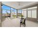 Bright sun room with floor-to-ceiling windows offering panoramic water views, a ceiling fan, and modern flooring at 4012 Marine Pkwy, New Port Richey, FL 34652