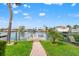 Tranquil waterfront view with private dock, lush lawn, and tropical landscaping, perfect for relaxing by the water at 4012 Marine Pkwy, New Port Richey, FL 34652