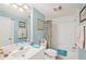 Well-lit bathroom featuring blue walls, a large mirror, and a shower/tub combo at 404 Laurel Lake Dr # 101, Venice, FL 34292