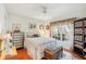 Cozy bedroom with a white ceiling fan and decorative furniture with a sunny window at 404 Laurel Lake Dr # 101, Venice, FL 34292