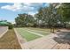 Outdoor shuffleboard court with lush greenery, framed by a clear blue sky and mature trees at 404 Laurel Lake Dr # 101, Venice, FL 34292