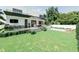 Backyard with a modern home featuring a pool, outdoor kitchen, and manicured lawn at 4103 W Knights Ave, Tampa, FL 33611