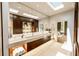 Beautiful bathroom featuring dual sinks, modern fixtures, under cabinet lighting and large mirror with artwork at 4103 W Knights Ave, Tampa, FL 33611
