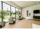 Cozy living room featuring floor-to-ceiling window views of backyard and comfortable seating arrangement at 4103 W Knights Ave, Tampa, FL 33611